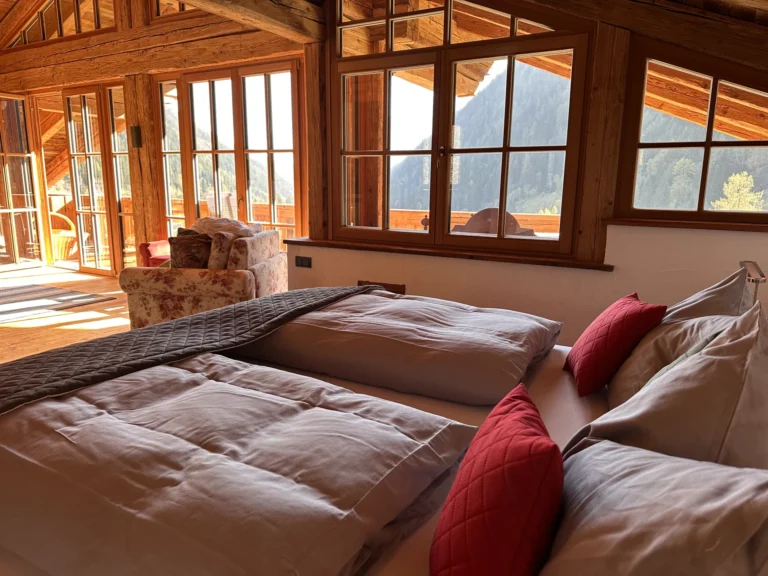 Doppelbett an der großen Fensterfront der Panorama-Suite