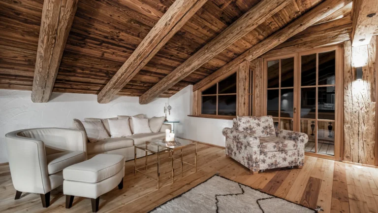 Sofa und Sessel unter der Holzdecke der Panorama-Suite am Abend