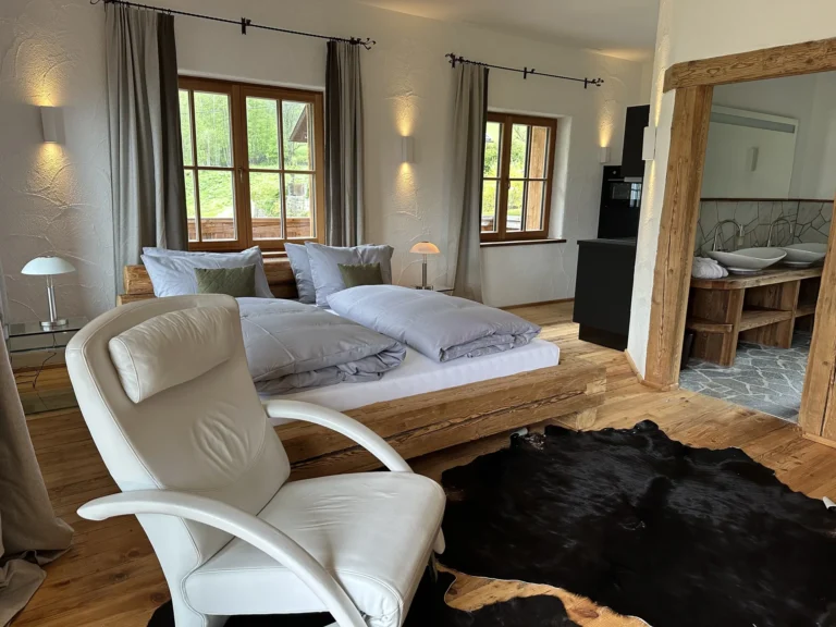 Doppelbett aus massivem Altholz und offener Badzugang im Studio Wasserfall