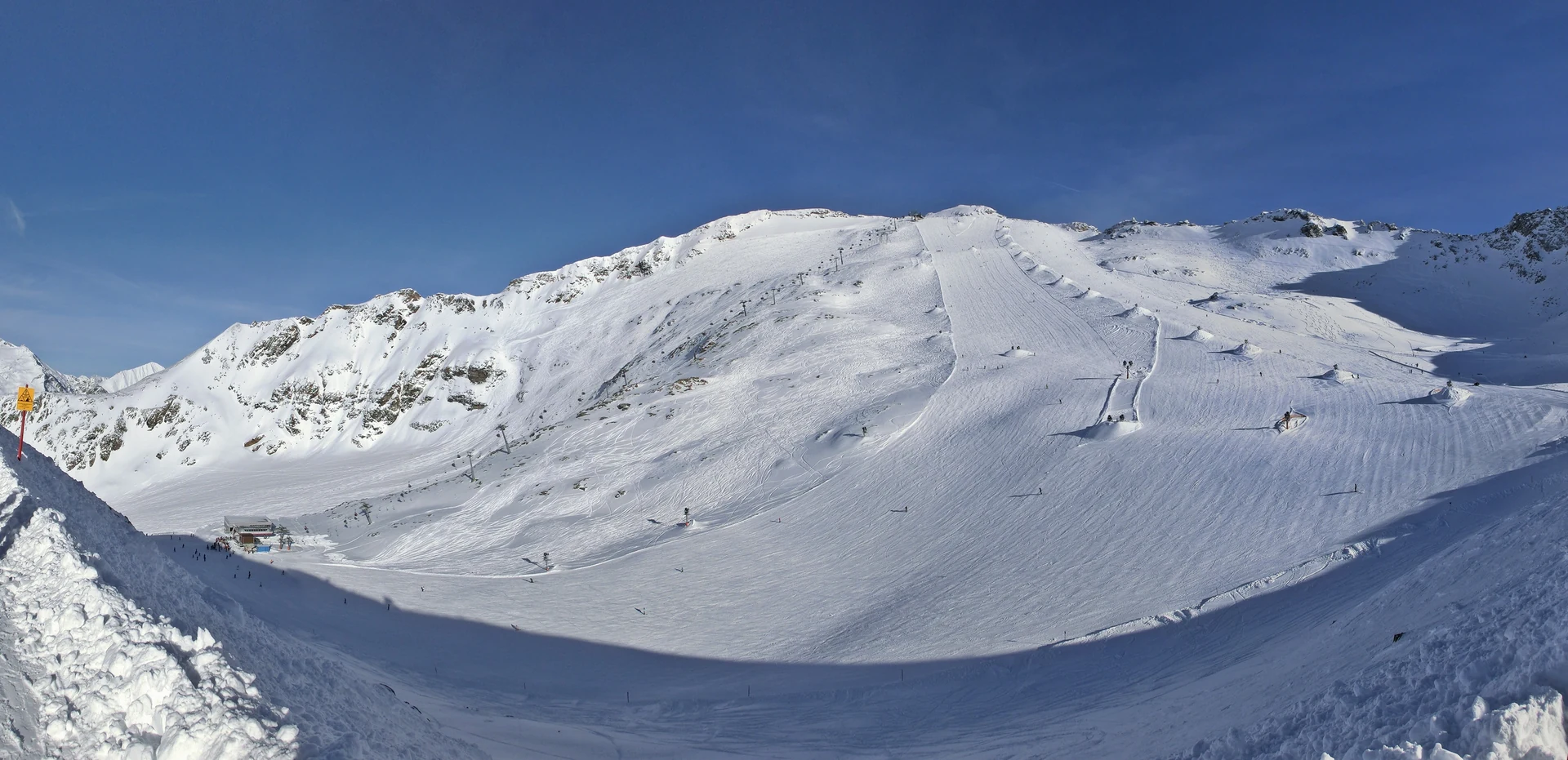 Skipisten und Liftanlagen am Mölltaler Gletscher vor verschneiten Bergen, Aufnahme 2012