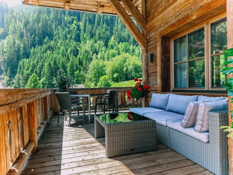 Überdachte Holzterrasse des Studios Wasserfall mit Sitzgruppe und Blick ins Grüne